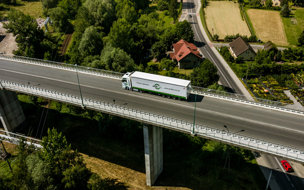 Branża TSL. Zestaw ciągnik z naczepą w czasie transportu towarów.